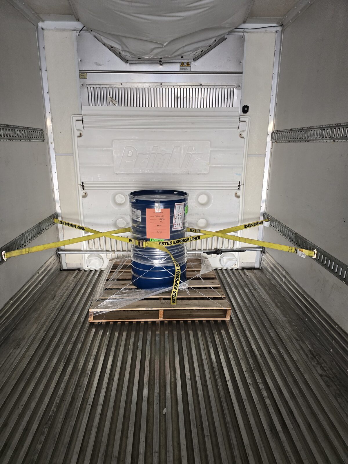 Steel drum strapped to a pallet inside a DT Trans LLC reefer trailer