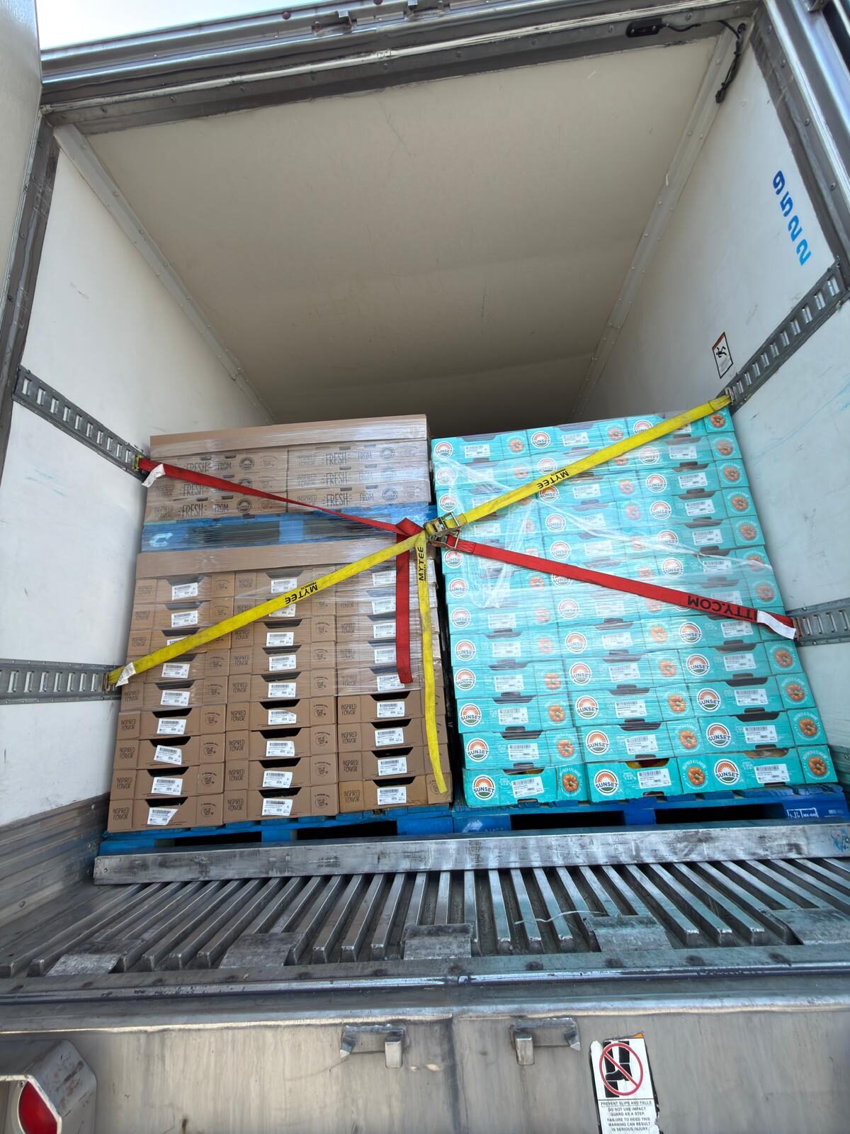 Two pallets of fresh produce cartons secured inside a DT Trans LLC trailer