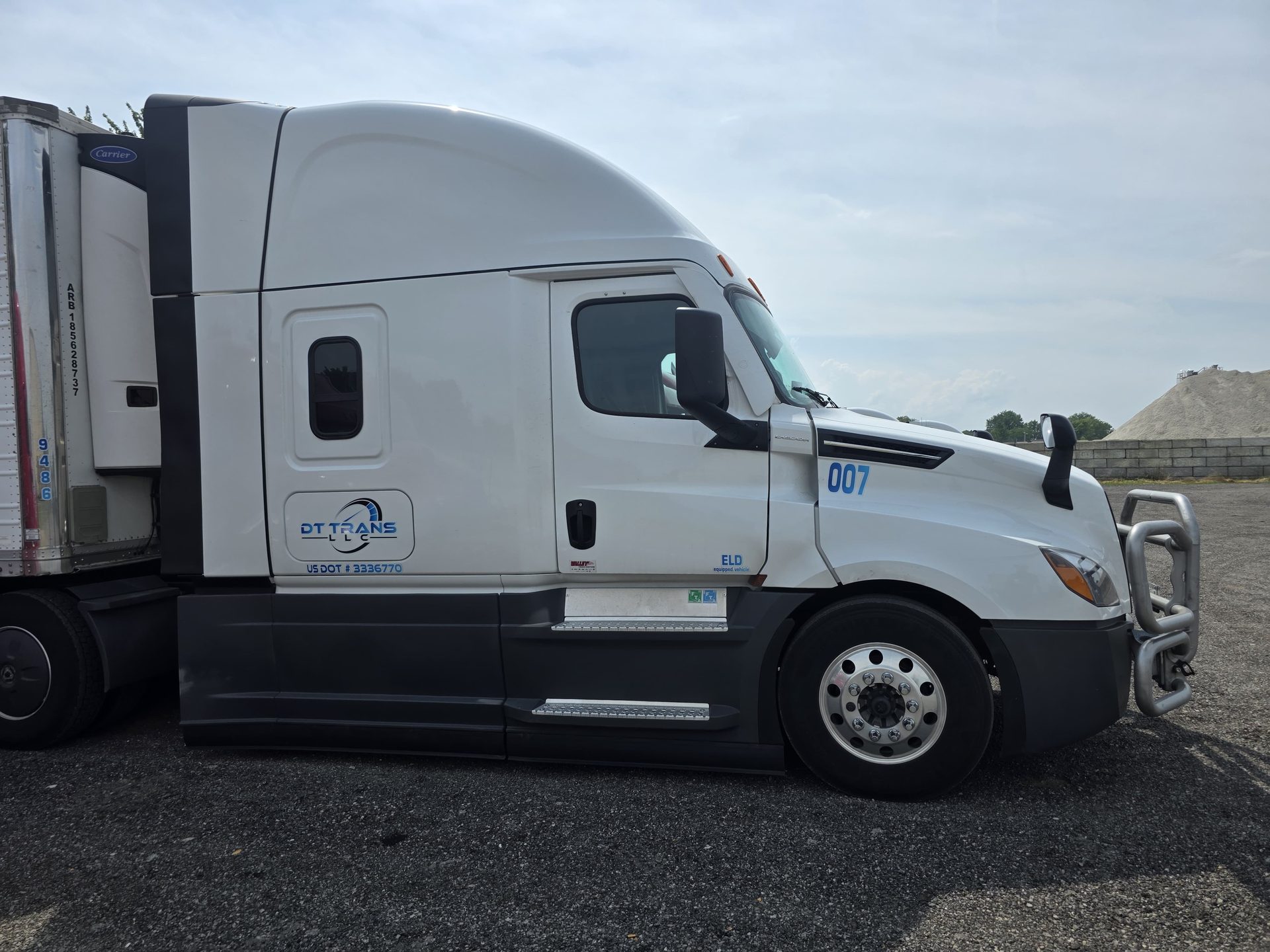 DT Trans LLC Volvo VNL 860 refrigerated tractor, front three-quarter view